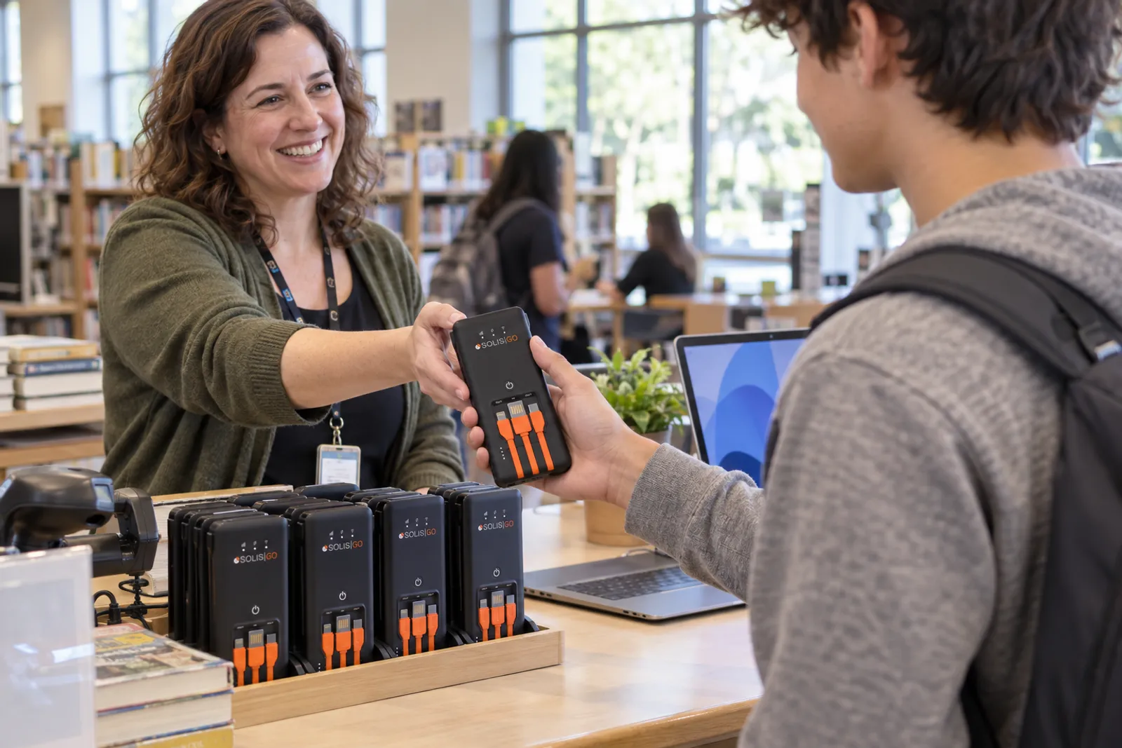 Librarian lending a hotspot to a student